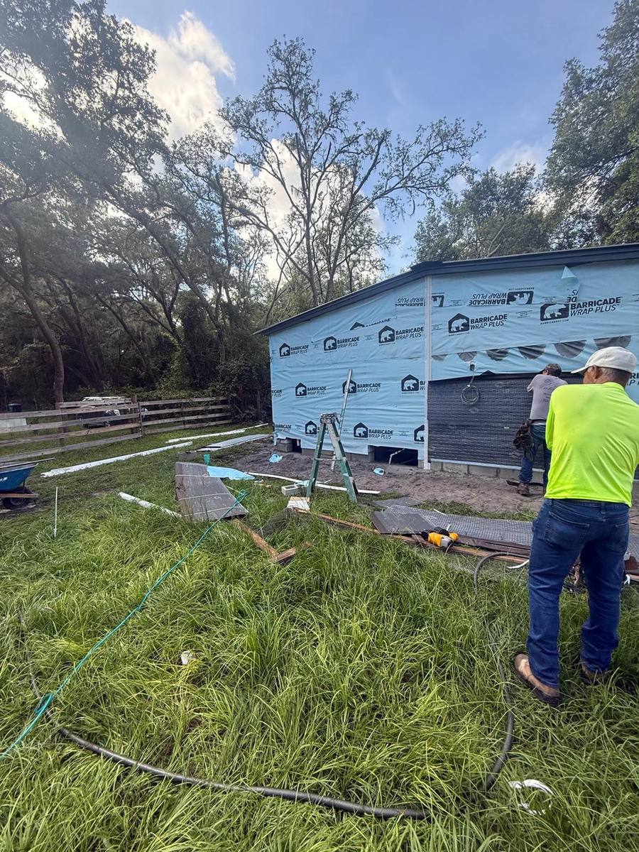 Crew installing moisture wrap on exterior walls