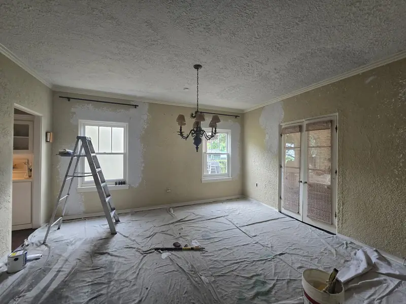Walls patched and spot-primed, floors protected for a full repaint