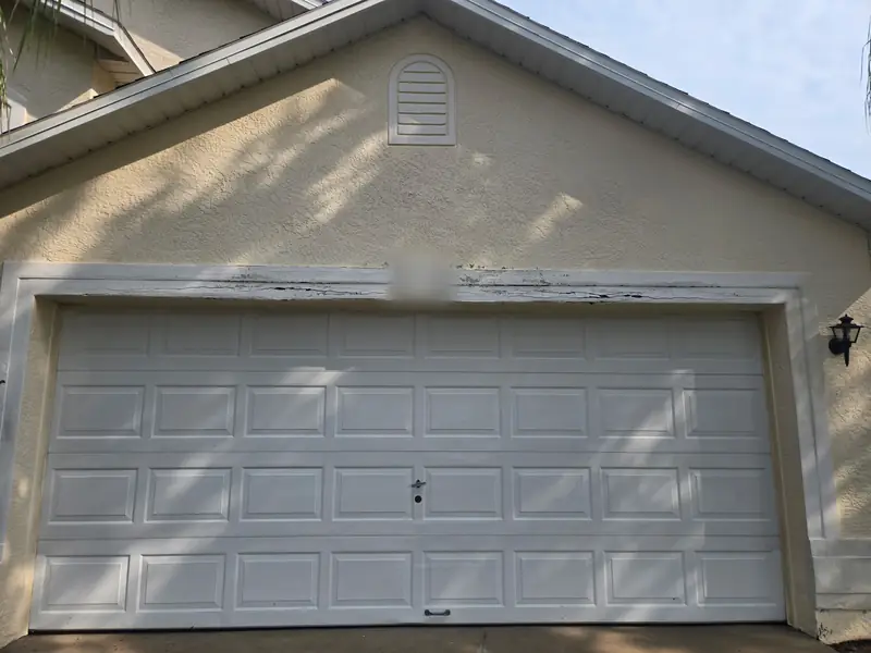 Rotted header trim above the garage door, marked for replacement