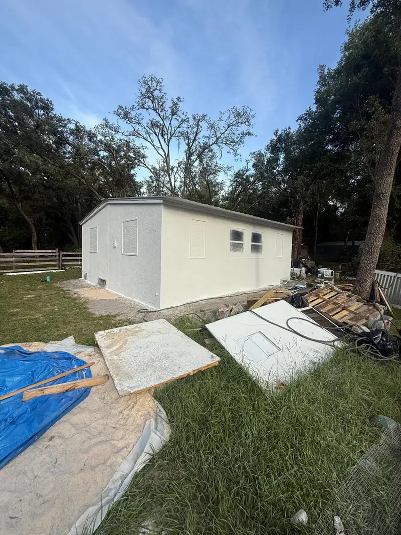 Stucco base coat applied over the prepared walls