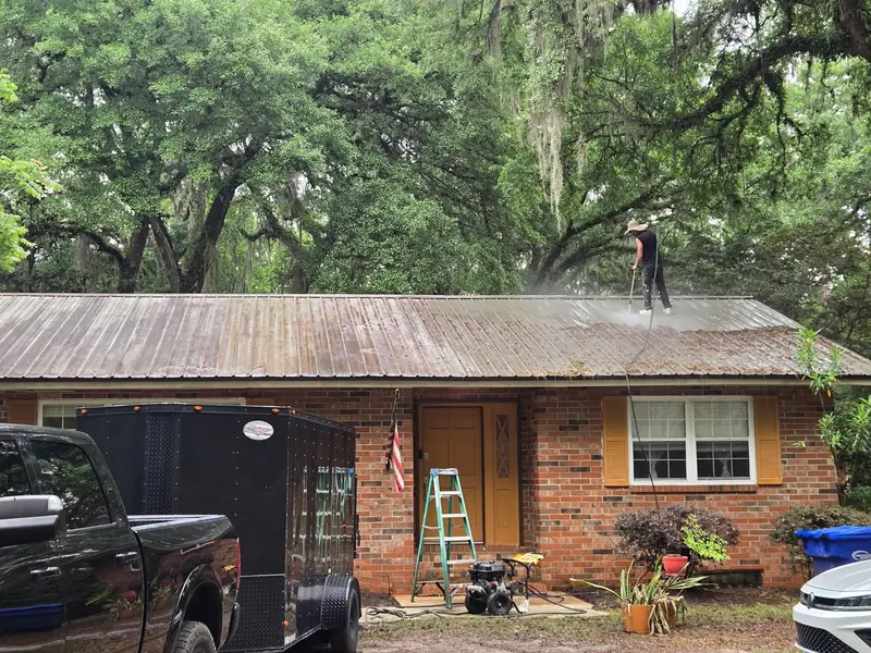 Pressure washing years of moss and mildew off the metal roof
